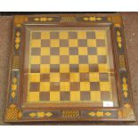A 19thC English inlaid mahogany chessboard, the border with chess related motifs and parquetry,
