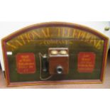 A painted wooden wall plaque for the National Telephone Company, mounted with a telephone handset,