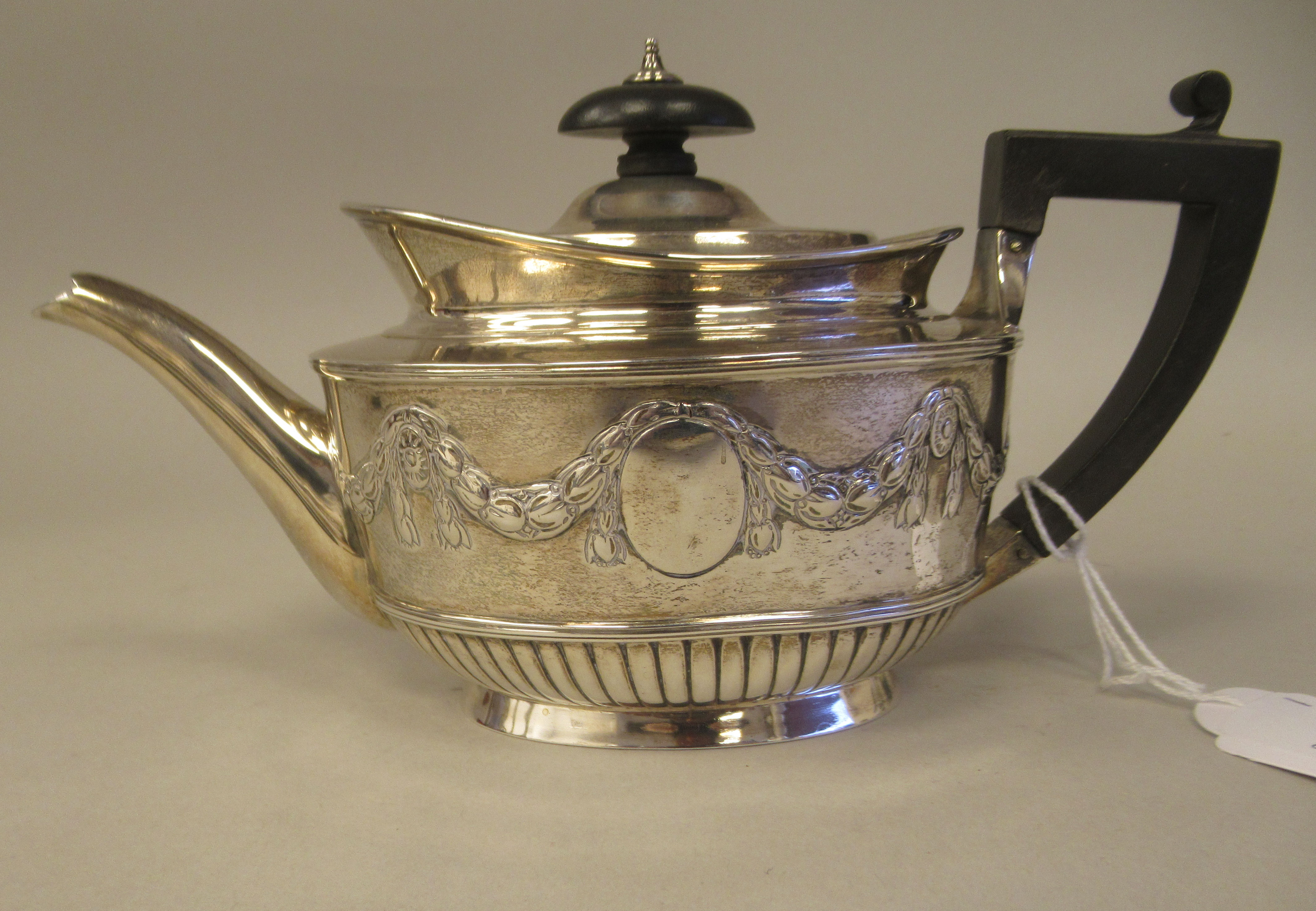 A late Victorian silver batchelors oval teapot with embossed garlands, drapes and demi-reeded