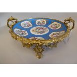 A 19thC Serves porcelain shallow dish, decorated with gilded vignette studies of mixed flora, on a