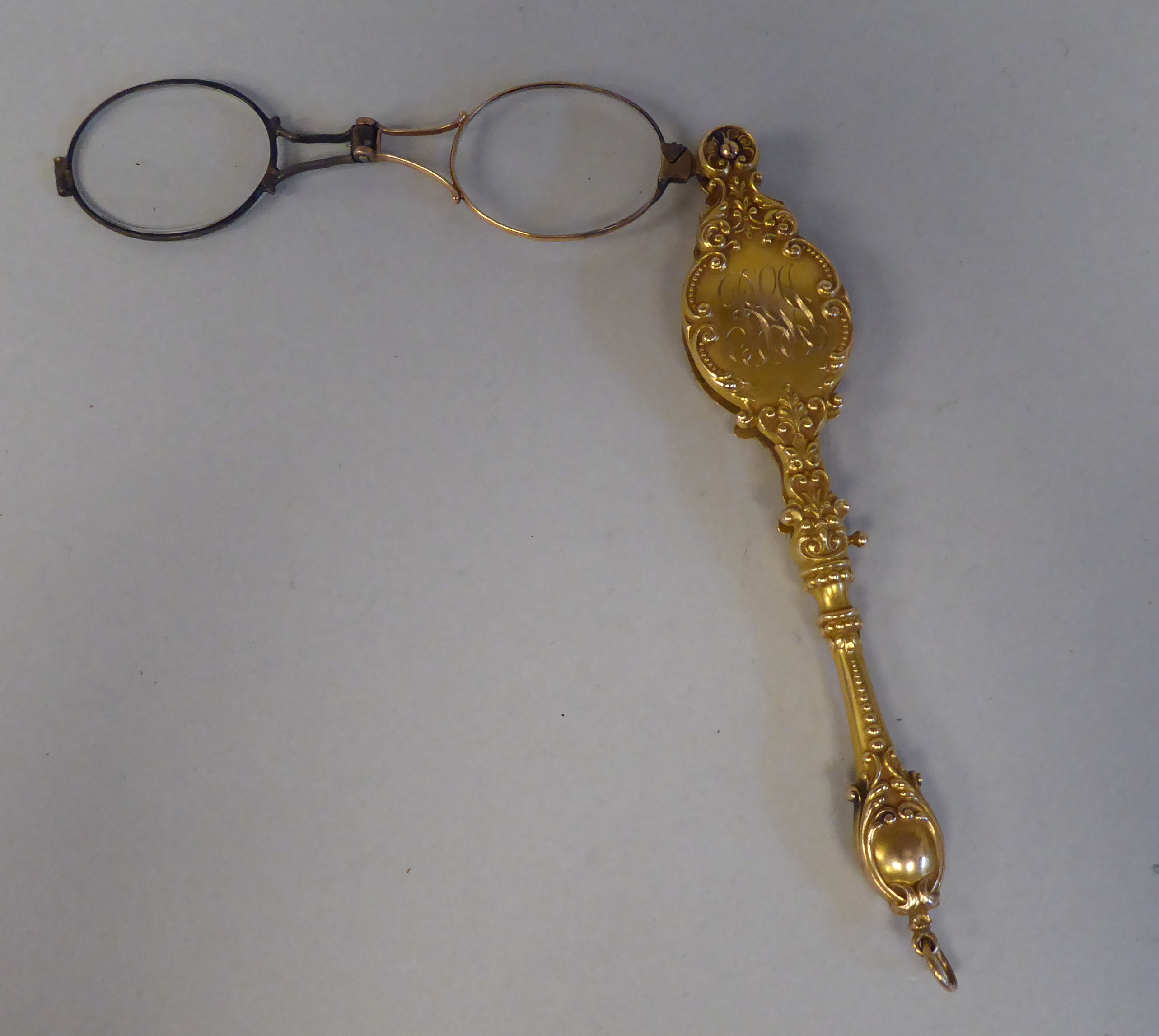 A late 19thC gilt metal mounted lorgnette, decoratively cast with engraved and other ornament and