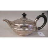 An Edwardian silver circular teapot of squat, bulbous form with a swept spout, insulated handle