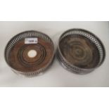 Two similar 19thC style silver wine coasters with uniformly pierced sides, on a turned mahogany base