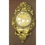 A 19thC style wall clock in an ornate gilt case, decorated with ribbons, flora and garlands; the
