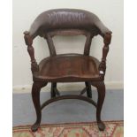 A late 19th/early 20thC mahogany framed horseshoe shape desk chair, the stud upholstered rexine