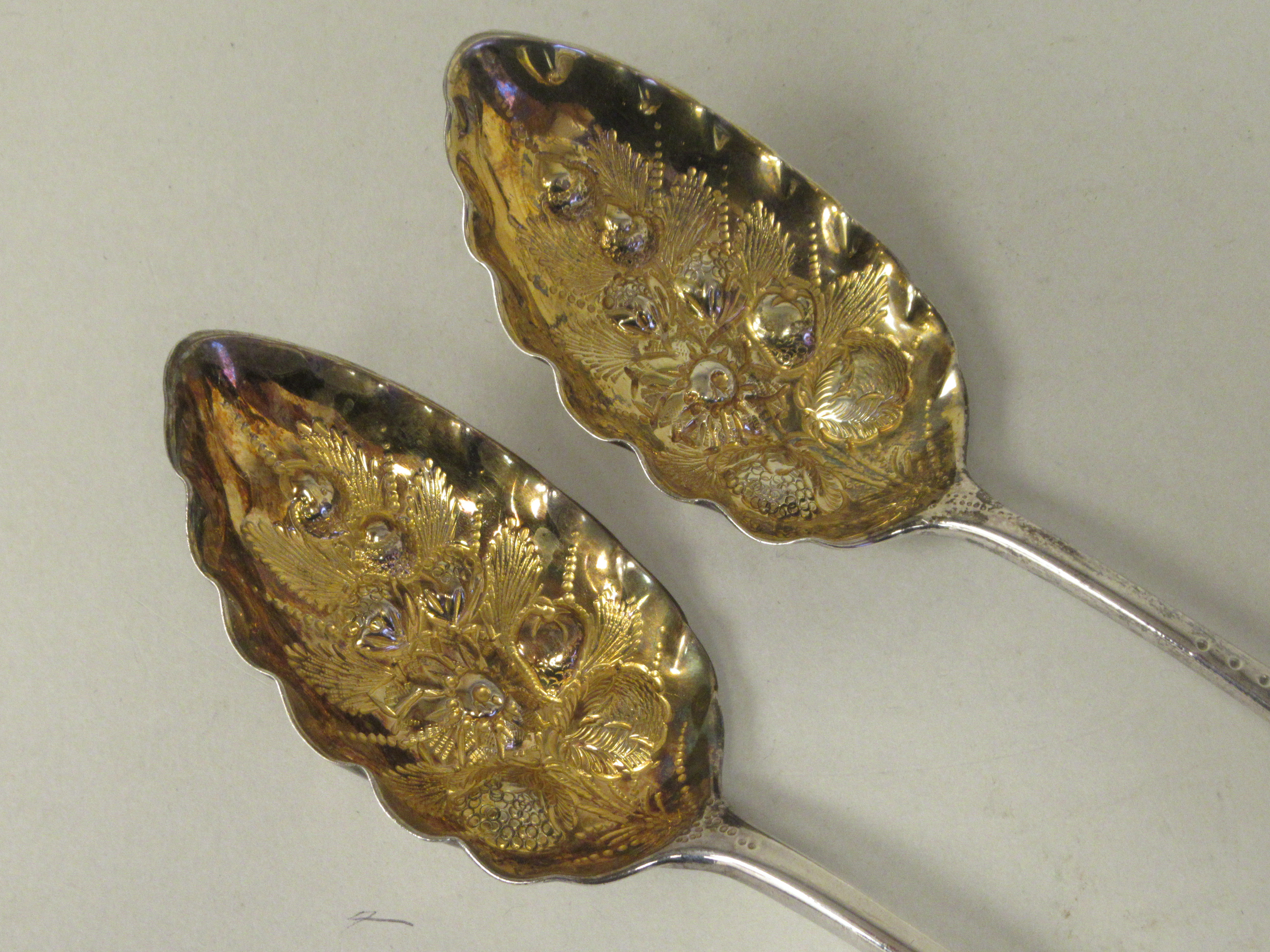 A pair of George III silver and parcel gilt Old English pattern berry spoons with foliate engraved - Image 3 of 4