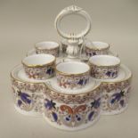 A late Victorian Staffordshire china egg cruet, comprising six pedestal cups, in a matching lobed