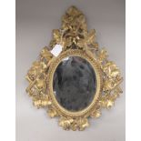 A 19thC oval mirror, set in an ornately, bead carved and floral decorated, giltwood frame  18" x 14"