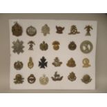 Twenty-four military cap badges and other insignia, some copies: to include The Sussex Regt.; King's