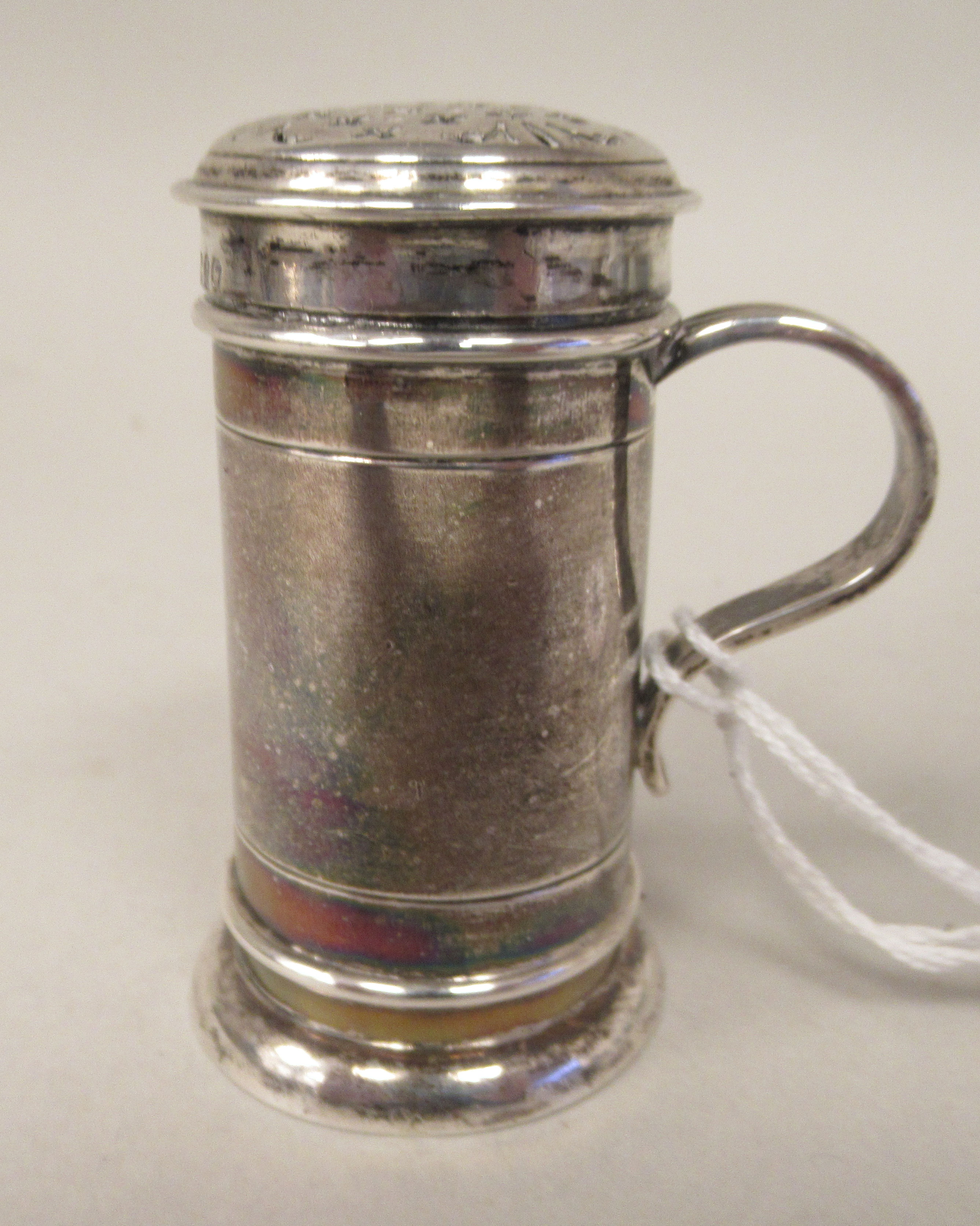 A late Victorian silver sander of cylindrical form with an S-shape handle and decoratively pierced