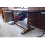 An early 20thC traditional oak Old English style refectory table, raised on opposing turned and