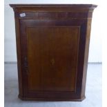A 19thC oak hanging corner cupboard with canted sides, enclosed by a lockable, panelled door  33"