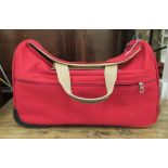A Lancel red fabric fight cabin bag with an extendable handle  21" x 11" x 13"
