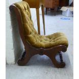 A late Victorian walnut showwood framed nursing chair, upholstered in old gold coloured fabric,