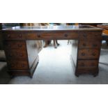 A late Victorian mahogany nine drawer, twin pedestal desk with a tooled hide scriber and bun handles