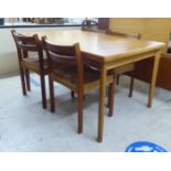 A 1970s teak draw leaf dining table, raised on turned, tapered legs  29"h  55"w extending to 93"L