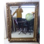 A 19thC mirror, set in a foliate, floral and shell moulded gilt frame  55" x 42"