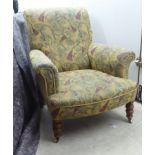 A late Victorian gentleman's armchair with a low, scrolled back, enclosed level arms and an