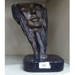 A modern bronze study of a face, on a black plaster base  bears the signature Hazel  12"h overall