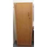 A G-Plan light oak moulded wardrobe, enclosed by a full height doors  69"h  24"w