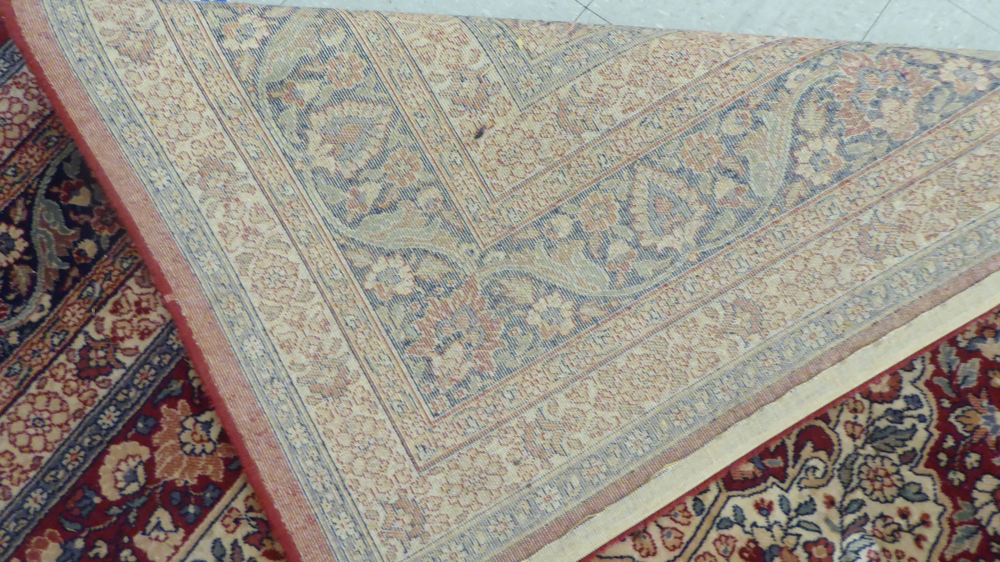 A modern Persian design machine made rug, decorated with flora in bright colours, on a red ground - Image 4 of 4