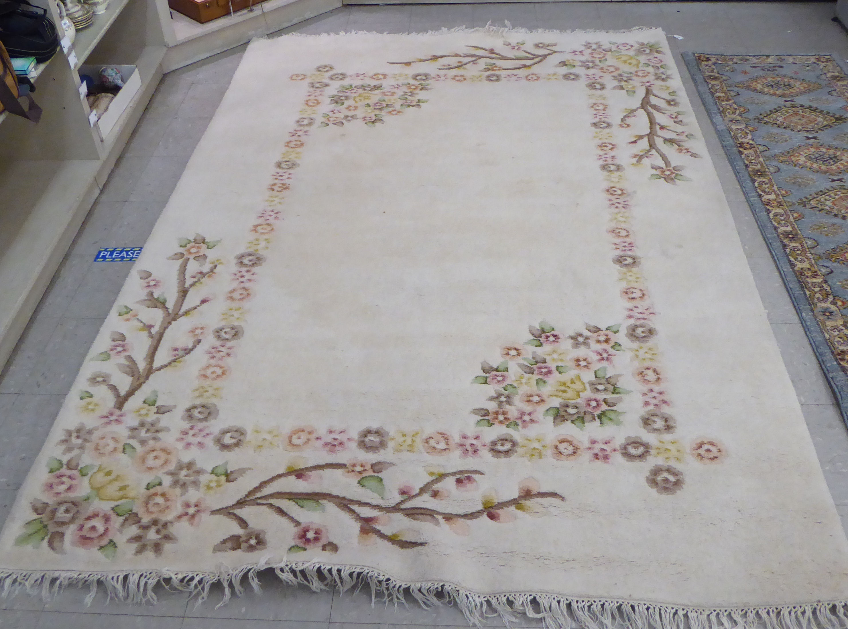 A modern woollen rug, decorated with flora, on a cream coloured ground  74" x 92"