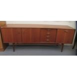 A G-Plan teak sideboard, comprising a pair of cupboard doors, an adjacent bank of four drawers and a