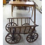 An early 20thC dog cart with a T-bar handle and wrought iron rimmed wheels  32"L