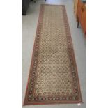 A machine made Persian design runner, decorated with repeating floral designs, on a multi-coloured