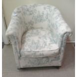 A mid 20thC tub design bedroom chair, upholstered in printed green and cream coloured fabric with