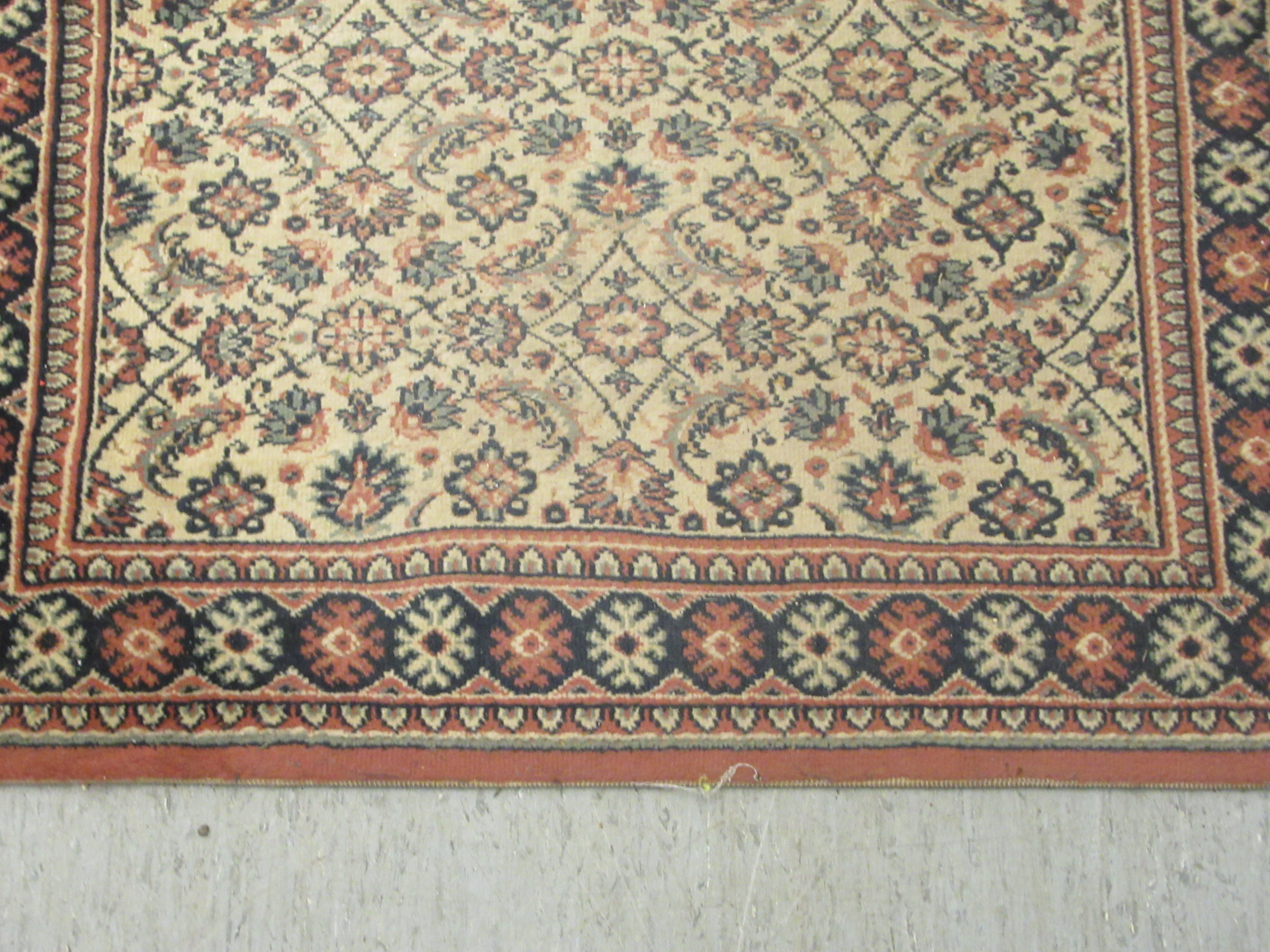 A machine made Persian design runner, decorated with repeating floral designs, on a multi-coloured - Image 2 of 5