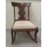 A 19thC and later mahogany framed rocking chair with a curved bar crest and vase design splat, the