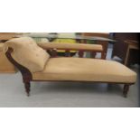 A late Victorian carved mahogany framed chaise longue with a level back and scrolled end, part