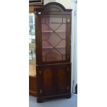 A modern reproduction of a 19thC mahogany standing corner cupboard with an arched, dentil moulded