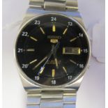 A vintage Seiko 5 automatic, stainless steel cased bracelet watch, faced by a black baton dial