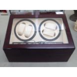 An eclectic walnut finished watch winder/storage case, the hinged lid enclosing two timed, clockwise