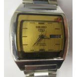 A vintage Seiko 5 automatic stainless steel cased bracelet watch, faced by a gilt baton dial with