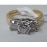 A gold coloured metal, three stone claw set diamond ring