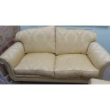 A modern Omega Furniture three person settee, upholstered in patterned cream coloured fabric, raised