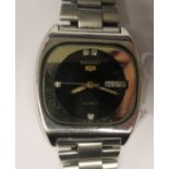 A vintage Seiko 5 automatic stainless steel cased bracelet watch, faced by a black dial with a day