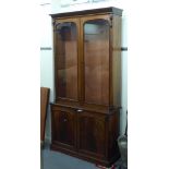 A mid Victorian mahogany cabinet bookcase, the upper part with a straight cornice, on a pair of