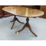 A 20thC Regency style mahogany, twin pedestal dining table, raised on splayed legs  30"h  64"L