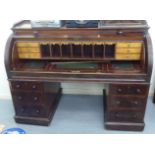 A late Victorian mahogany cylinder desk, enclosing a part fitted interior, over two, three drawer