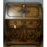 A 1920's carved oak bureau with fitted interior