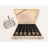 A 1930s cased set of silver spoons, and a silver toast rack.