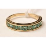 An 18ct gold and green tourmaline half-hoop eternity ring
