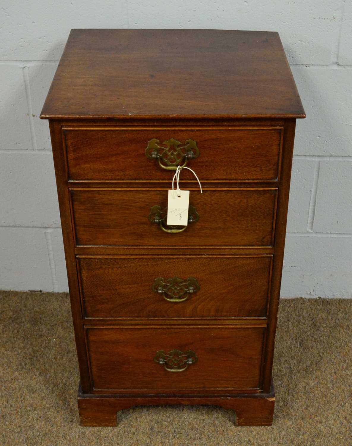 A reproduction small chest of four drawers.