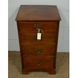 A reproduction small chest of four drawers.