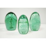A selection of Victorian and later green glass dump paperweights