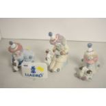 Three Lladro figures; and a Lladro plaque.